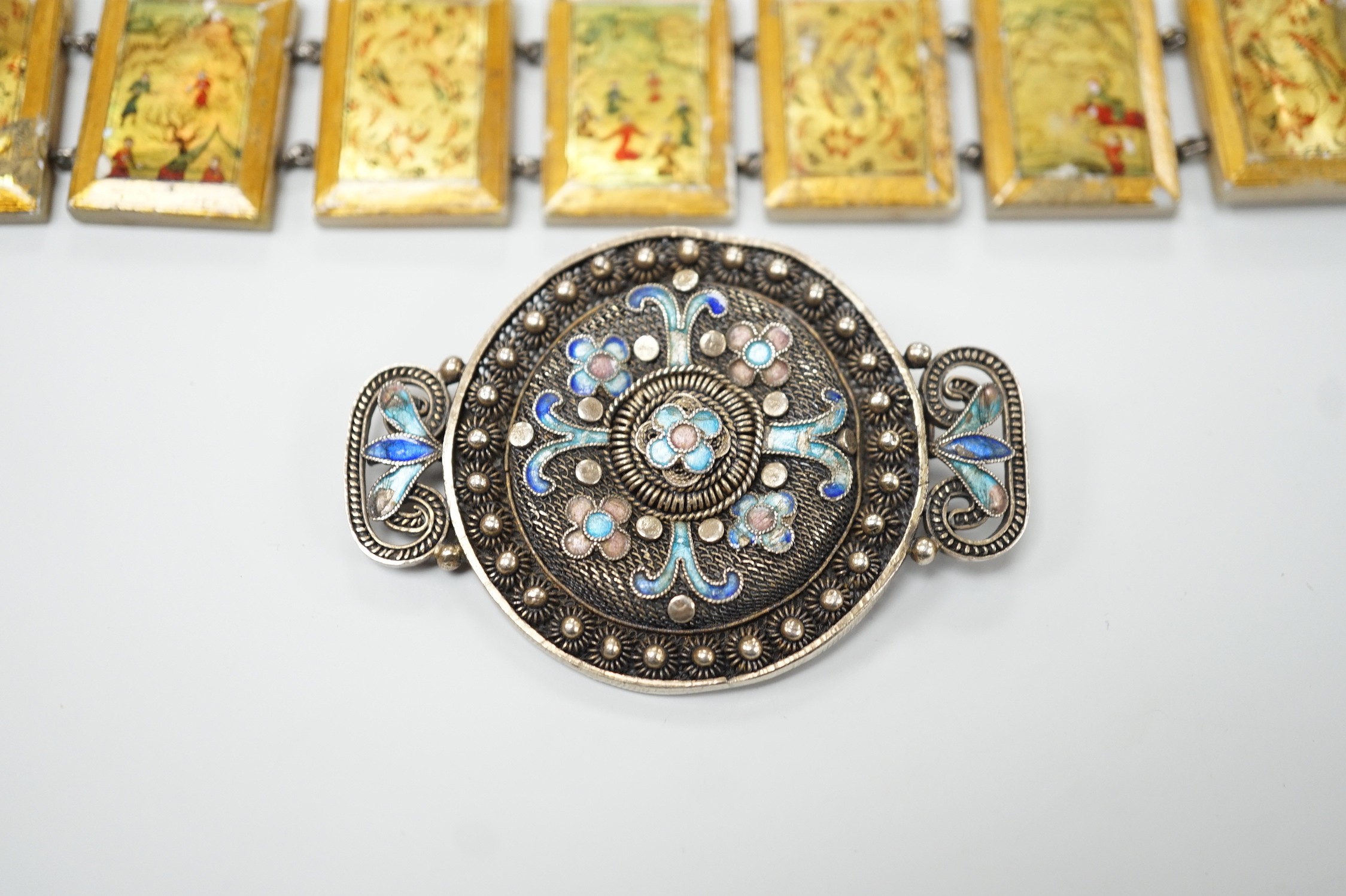 A Persian lacquered mother of pearl panel bracelet, 17cm and a Chinese filigree white metal and 'kingfisher' enamelled brooch, 54mm.